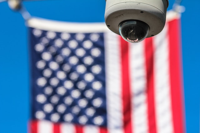 A surveillance camera near a US flag